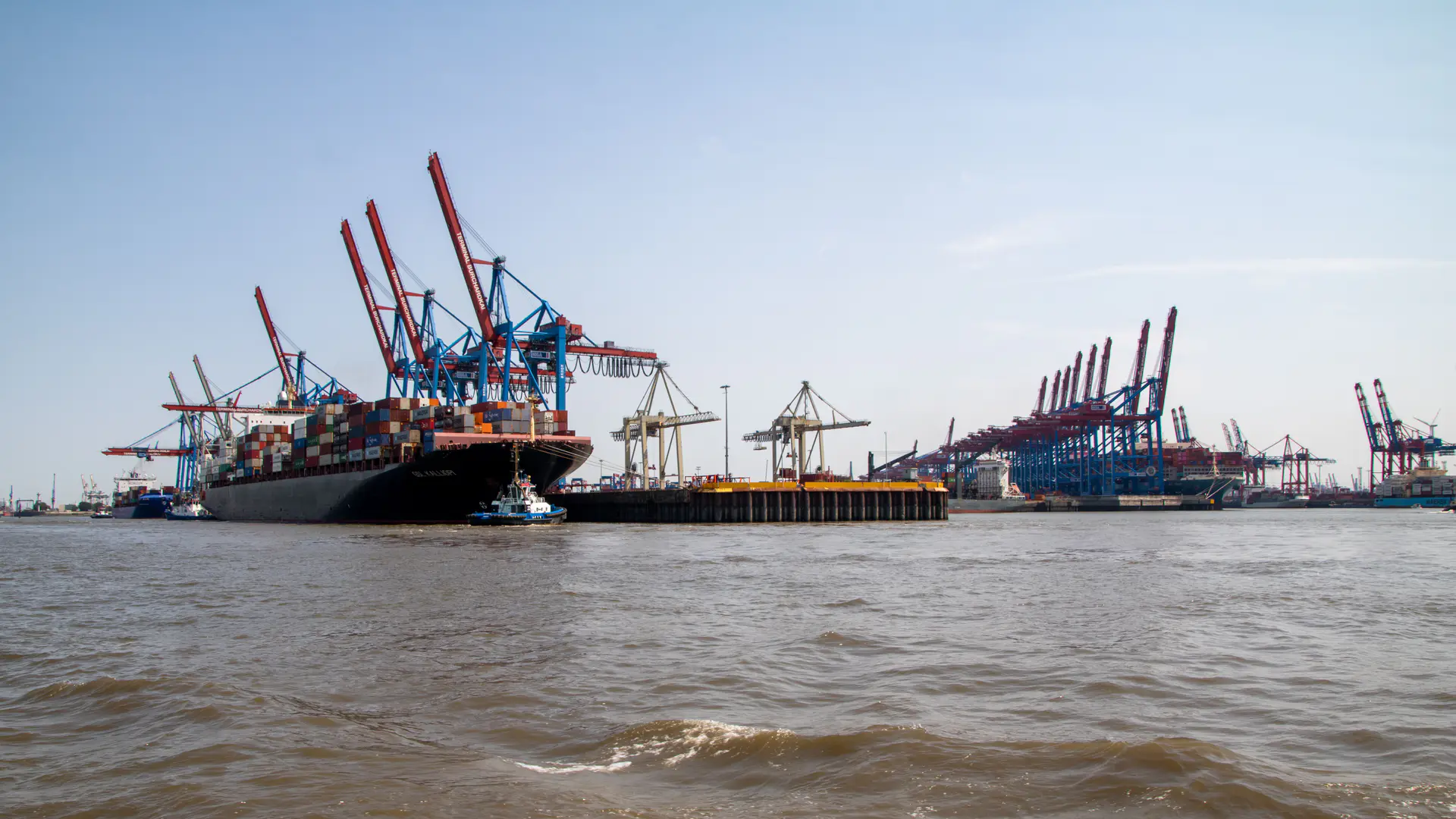 Container ship alongside a quay with gantry cranes working across the waterfront