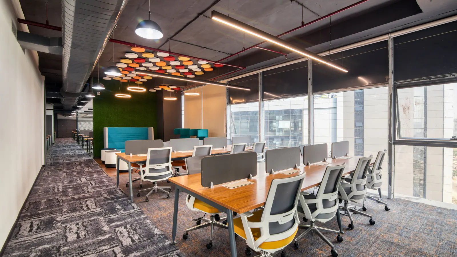 Open-plan office with shared desks, task chairs and full-height windows